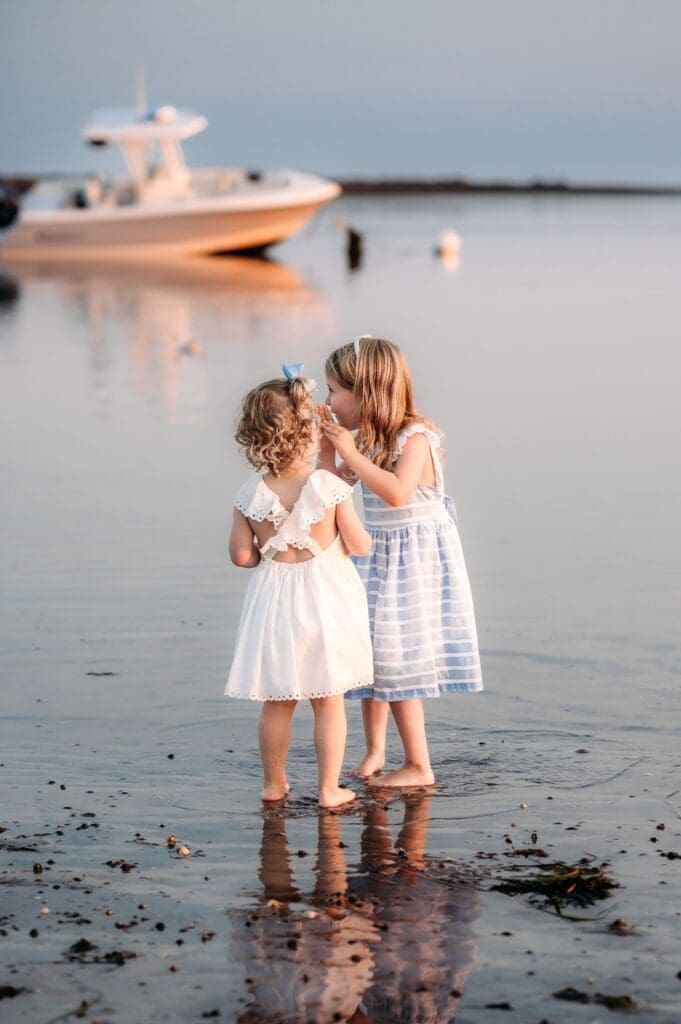 Sisters telling a secret at their maine beach photo session